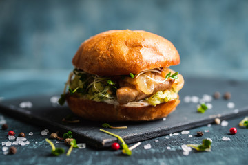 Fresh tasty burgers with roasted chicken, potato, micro greens and different herbs on the rustic background. Selective focus. Shallow depth of field.