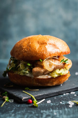 Fresh tasty burgers with roasted chicken, potato, micro greens and different herbs on the rustic background. Selective focus. Shallow depth of field.