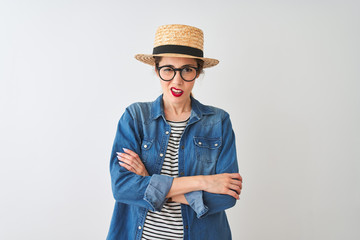 Redhead woman wearing denim shirt glasses and hat over isolated white background skeptic and...