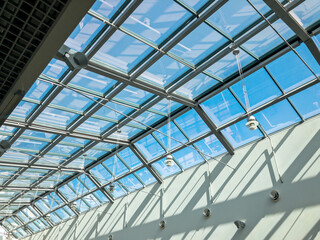 transparent glass ceiling of the modern building under bright blue sky