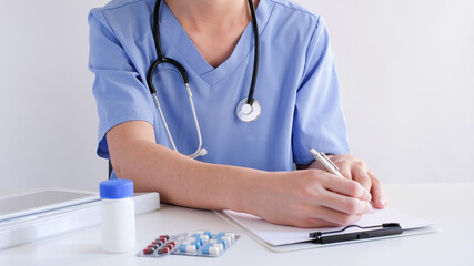 doctor working and hospital. prescribing prescription in the blue uniform.