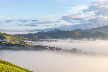 panorama image.View of village covered in foggy during morning sunrise colorful sky