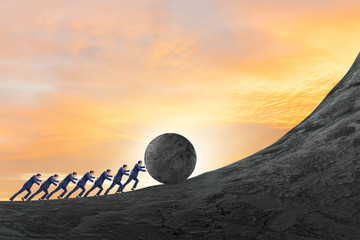 Team of people pushing stone uphill © Elnur