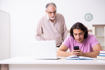 Fototapeta na wymiar Old father helping his son in exam preparation
