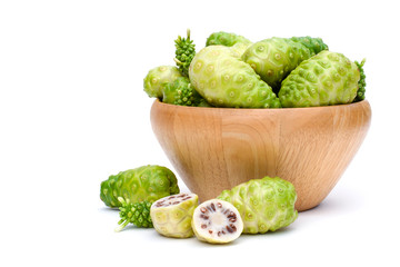 Closeup fresh Noni fruits (Common name Morinda citrifolia,indian mulberry, cheese fruit )in wooden bowl and cut in half sliced isolated on white background.Nature medicine plant and superfood concept 