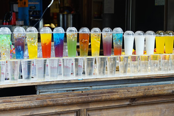 A Fruit Tea shops displaying their Colourful drinks at their shopfront. 