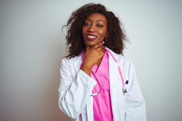 African american doctor woman wearing  pink stethoscope over isolated white background looking confident at the camera smiling with crossed arms and hand raised on chin. Thinking positive.