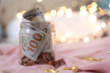 The money collected in the jar contains coins and 100 dollar bills with Credit card Visa -...
