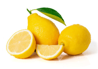 Closeup two fresh ripe organic yellow lemon fruits with water drops, green leaf and cut in half slice isolated on white background with clipping path. Healthy fruit and food concept. 