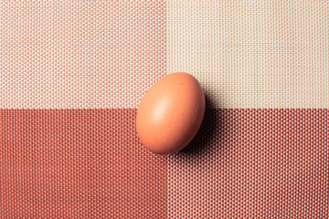 Yellow egg on beautiful tablecloth.