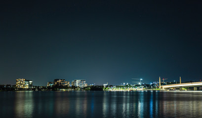 Fototapeta na wymiar View of Canberra city at night looking over Lake Burley Griffin showing Commonwealth Bridge at right 