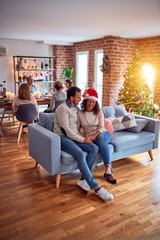 Obraz premium Family and friends dining at home celebrating christmas eve with traditional food and decoration, romantic senior couple talking together sitting on the sofa