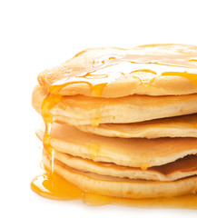 Stack of tasty pancakes with honey on white background