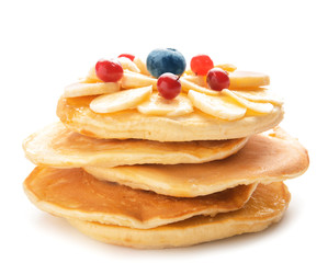 Stack of tasty pancakes with banana and berries on white background