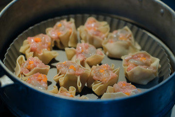Close up Traditional chinese food dumpling called Shumai in Thailand called kanom jeep. Cooking by steam in bamboo basket.