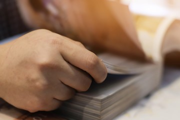 Close up of student hand opening and reading a book with sunlight.