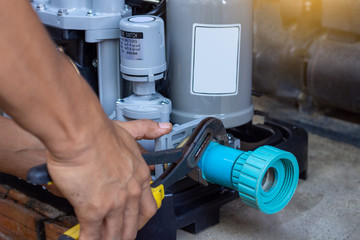 Technician worker man hand remove water check valve from the plastic pvc pipe line by using pipe...