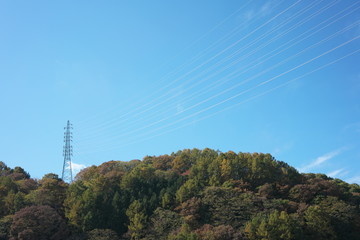Obraz premium Nagano,Japan-November 9, 2019: Power Grid Tower over mountain on blue sky background