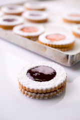 Christmas linzer Shortbread cookies filled with raspberry and apricot jam and dusted with powder sugar 