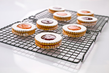 Obraz na płótnie Canvas Christmas linzer Shortbread cookies filled with raspberry and apricot jam and dusted with powder sugar 