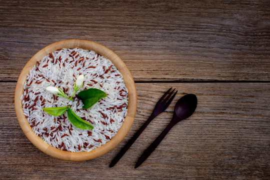 bowl of rice and jasmine flower on wood background