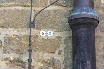 Wall of an old house made of stone blocks with an old drainpipe and lightning conductor wiring