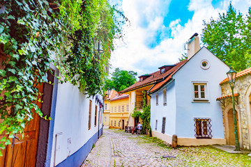 Narrow, empty, cozy street of an old European city with houses and a wall
