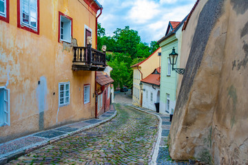 Narrow, empty, cozy street of an old European city with houses and a wall