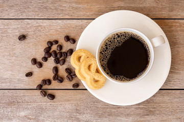 White ceramic cup of hot black coffee isolated on  wood table background. Top view. Flat lay.