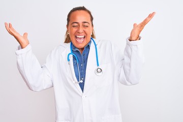 Middle age mature doctor woman wearing stethoscope over isolated background celebrating mad and crazy for success with arms raised and closed eyes screaming excited. Winner concept