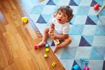 Fototapeta premium Beautiful toddler child girl playing with toys on the carpet
