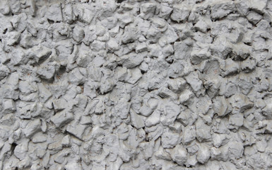 Closeup of a wall made of crushed stone and scrap brick plastered with cement
