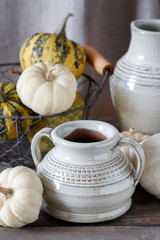 Ceramic vases and ripe pumpkins on wooden table.