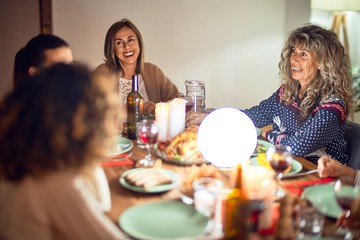 Beautiful group of women smiling happy and confident. Eating roasted turkey celebrating thanksgiving day at home