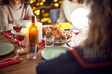 Beautiful group of women smiling happy and confident. Eating roasted turkey celebrating christmas at home