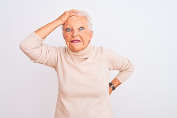 Senior grey-haired woman wearing turtleneck sweater standing over isolated white background smiling confident touching hair with hand up gesture, posing attractive and fashionable