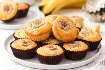 Banana muffins on a white plate. Sweet cupcakes with slice of fruit.