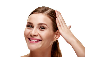 Happy woman with perfect clean skin touching her healthy hair