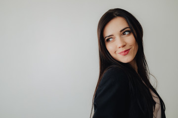 Fototapeta premium Young attractive emotional girl in business-style clothes on a plain white background in an office or audience