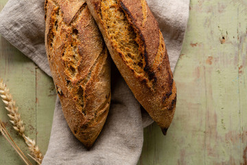 Two loaf of fresh breads on rustic wood