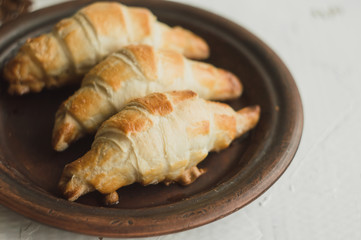 Homemade croissants on a handmade clay plate.
