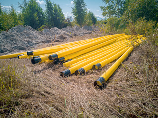 Construction site of an overland gas pipeline. There is a trench dug over a field, next to it there...