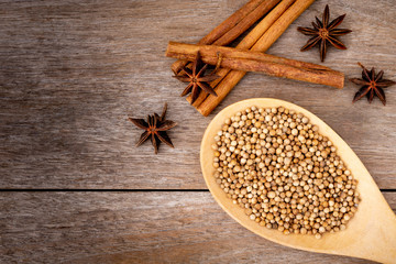 Closeup Cinnamon sticks ,star anise and coriander seeds in wooden spoon   isolated on wood table background. Natural herbal plant,spices seasoning conceptual. Space for text.