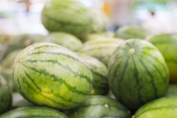 Fresh watermelon in the supermarket. partial view of woman picking watermelon in grocery shop.