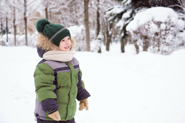 Fototapeta na wymiar Cute child playing in a snow. Winter activities for kids.