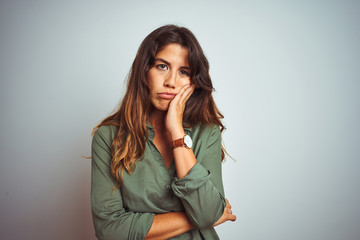 Young beautiful woman wearing green shirt standing over grey isolated background thinking looking...
