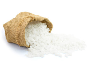Closeup pure natural sea salt in brown sack bag isolated on white background. Clipping path.
