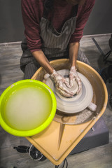 Making pottery by hand to make a container. woman's hands close up, the masterful studio of ceramics works with clay on a potter's wheel