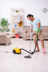 Young injured man cleaning the house