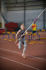 Pole vaulting - woman is running with a long pole in her hands